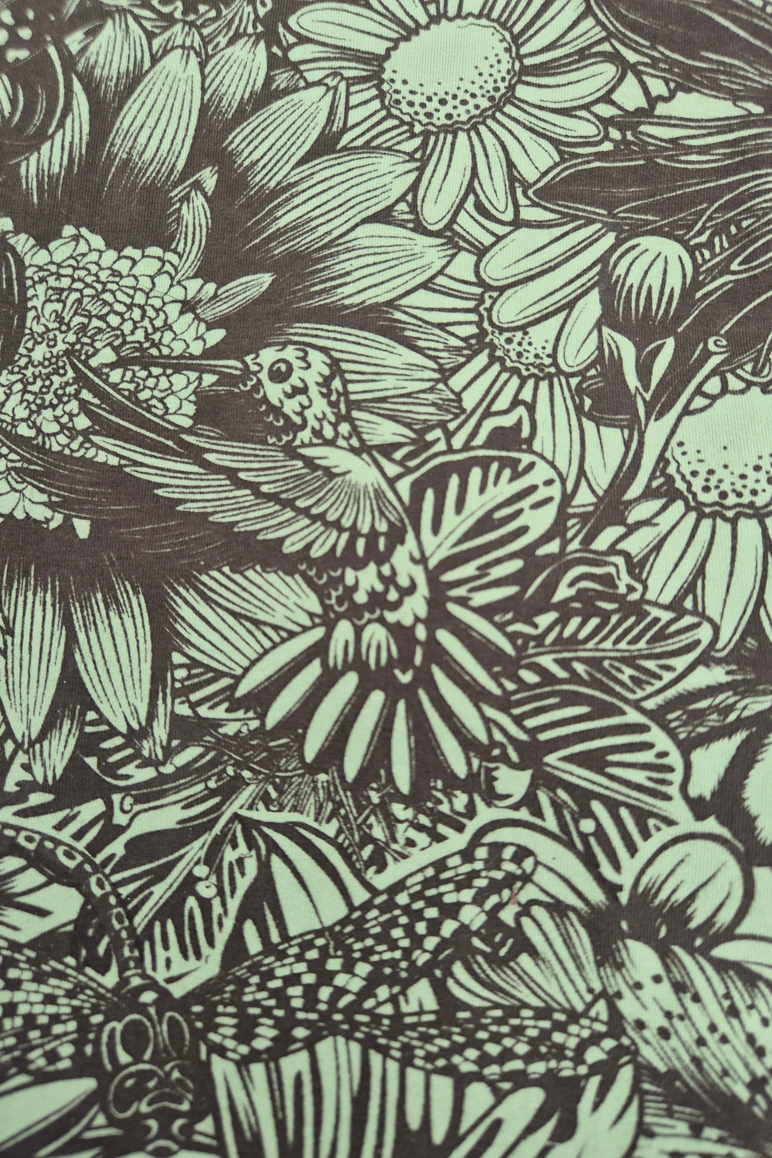 Bloom print of a hummingbird among flowers and leaves in green and olive