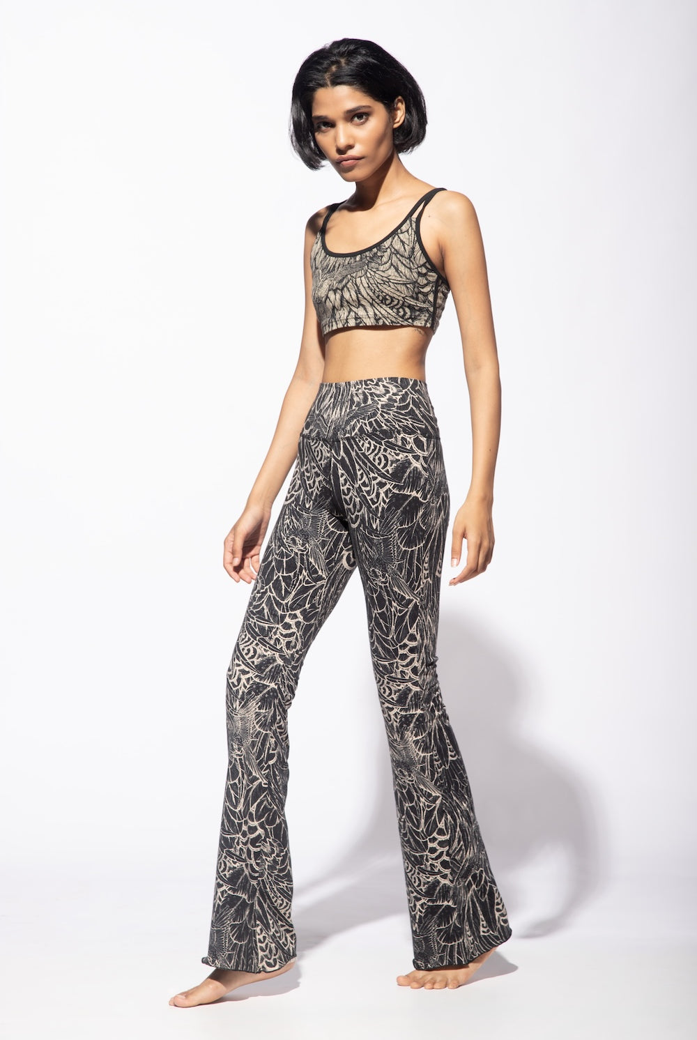Woman wearing Feather Cream Black Flares with a matching cross back bra top seen from the front.