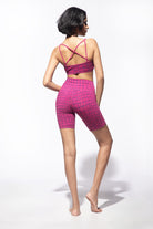 model wearing fuchsia purple crocodile bike shorts with cross back bra top with built in bra, shown from the back