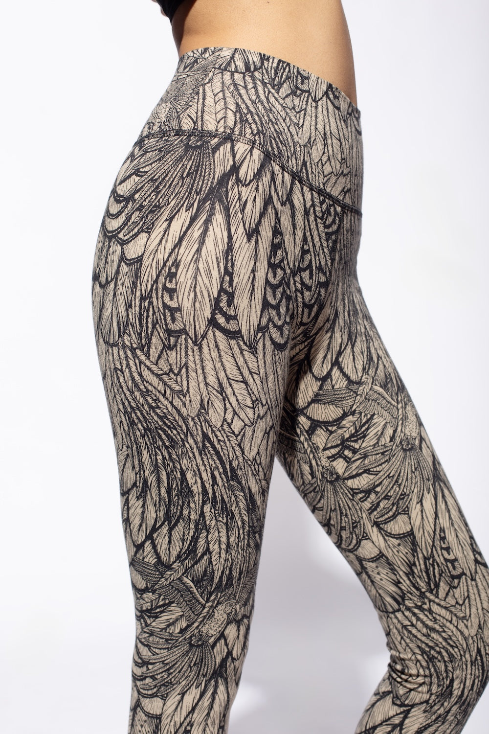 Woman wearing cream black feather printed capri leggings made from cotton lycra shown from side close up - funky simplicity