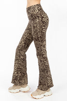 A woman wearing Funky Simplicity wild animal-print flared leggings in cream brown color shown from the side.