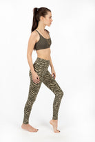 Woman wearing cream and olive zebra print high-waist leggings with a cross-back sport bra in comfortable cotton lycra fabric from Funky Simplicity - perfect for yoga, fitness, and loungewear. Sideways