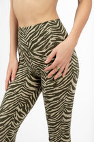 Woman wearing cream and olive zebra print high-waist leggings in comfortable cotton lycra fabric from Funky Simplicity - perfect for yoga, fitness, and loungewear. Close-up