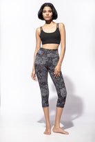 Woman wearing Nagomi Capri leggings in Grey Black. Worn with a Black Cross back bra from Funky Simplicity - shown from the front