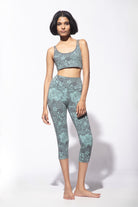 Woman wearing Nagomi Capri leggings in Light Blue (mizu) and light grey. Worn with a matching Cross back bra from Funky Simplicity - shown from the front